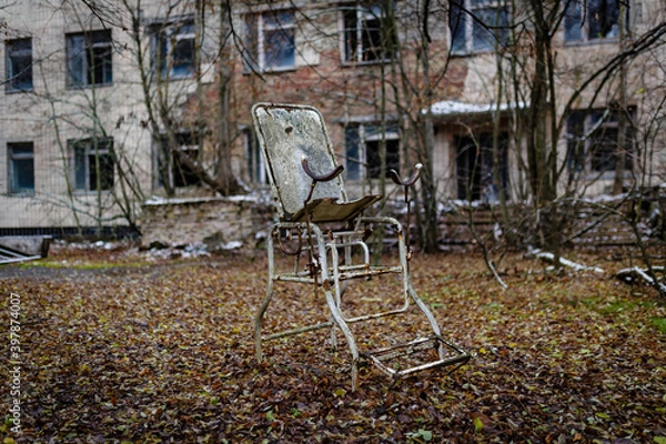 Obraz Abandoned gynecological chair against the background of a hospital building in the abandoned city of pripyat