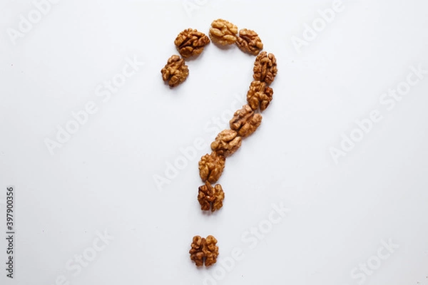 Fototapeta Question mark made out of peeled walnuts placed on a white background