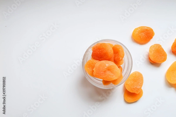 Fototapeta Top view of dry apricots placed around and in of a glass cup