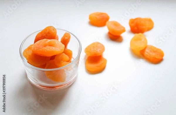 Fototapeta Top view of dry apricots placed around and in of a glass cup