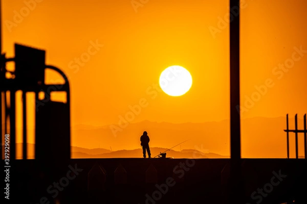 Obraz 朝陽と釣り人