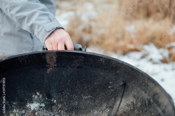 Fototapeta Mann zieht einen Kugelgrill