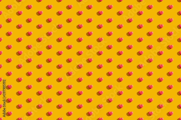 Fototapeta Valentine Day. Orange seamless background. Red heart pattern. Romantic congratulation. Love symbol ornament minimalist symmetrical composition isolated on bright yellow.