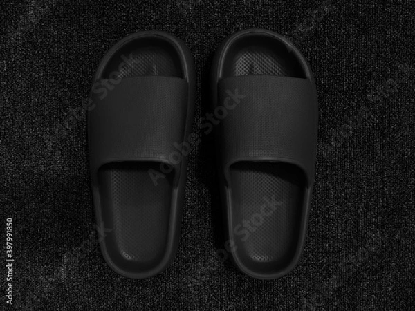 Obraz Monotone color of pairs of black rubber slipper for indoor on black carpet background.