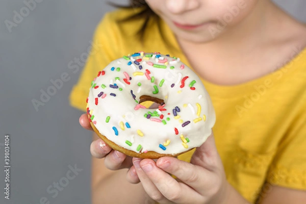 Fototapeta close up of hands hold a glazed white doughnut