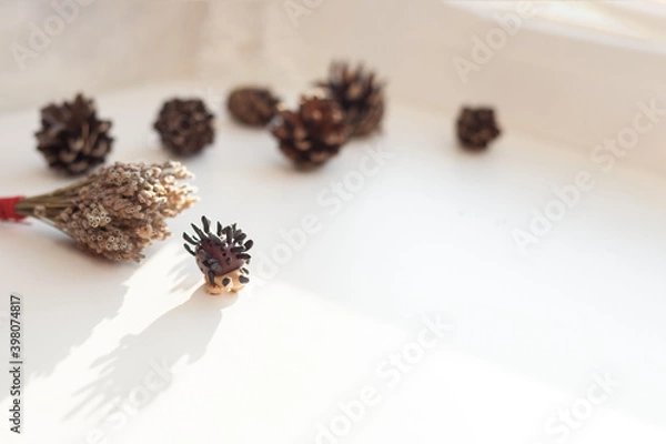 Fototapeta A small hedgehog made of clay with needles on a light background. Shadi's bumps in the blur