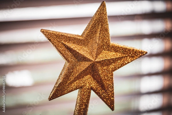 Fototapeta A golden glitter star for the top of a Christmas tree