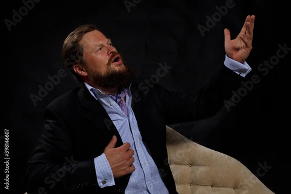 Fototapeta Solid bearded man in suit singing opera studio portrait