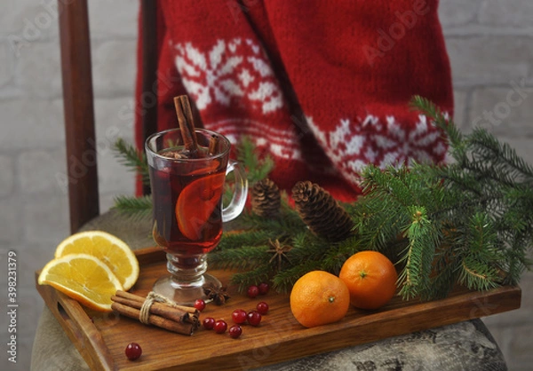 Fototapeta Hot mulled wine with cinnamon sticks, star anise, spruce branches, tangerines, cranberries and a red knitted sweater.