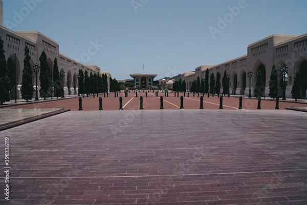 Fototapeta a courtyard with pillars and a building in the background