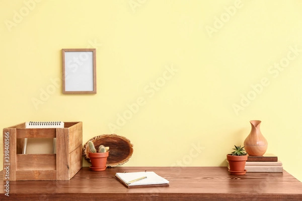 Fototapeta Stylish workplace with blank photo frame near color wall