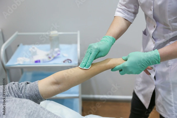 Fototapeta waxing procedure in the beautician's office. woman's hand epilation with wax strip