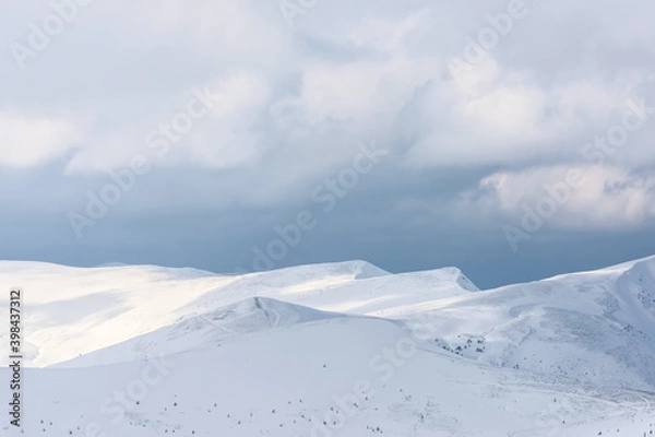 Obraz Snow-covered mountain range under a cloudy sky.