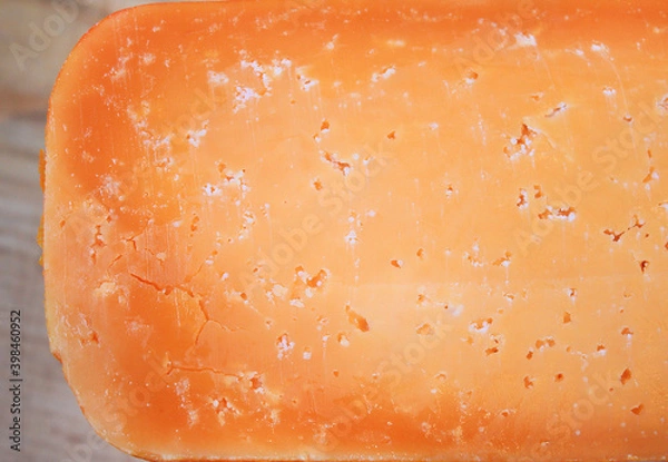 Fototapeta Ser Cheddar Farmera z ziarnami w środku. Tekstura jako ręcznie robione sery dojrzewają. Pomarańczowy biały stały ser strzegący sera