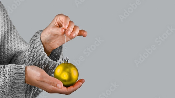 Fototapeta Illuminating and Ultimate gray Pantone color of the year 2021 presentation. Female hands holds christmas ball.