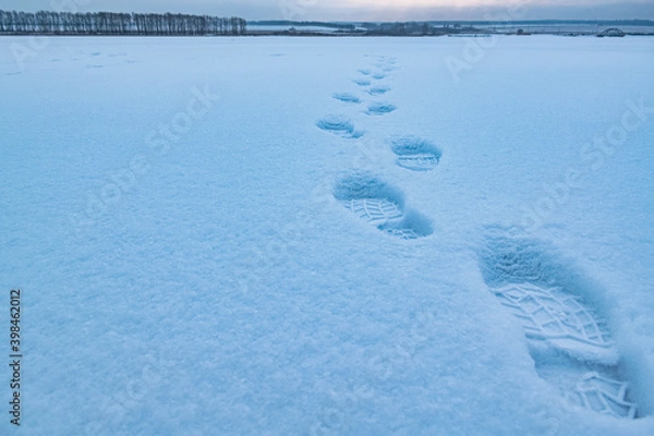 Obraz Fresh footsteps on the snowy ice of the river.