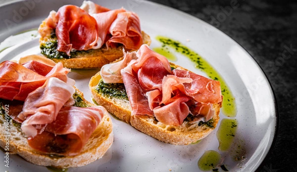 Obraz Bruschetta with prosciutto and pesto sauce on plate