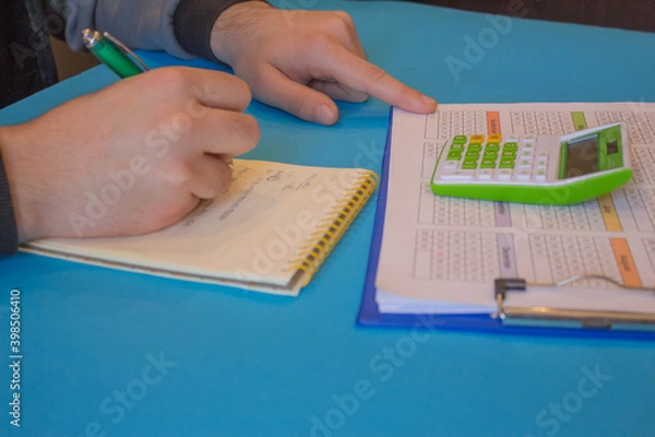 Fototapeta Close up view of bookkeeper or financial inspector hands making report, calculating or checking balance