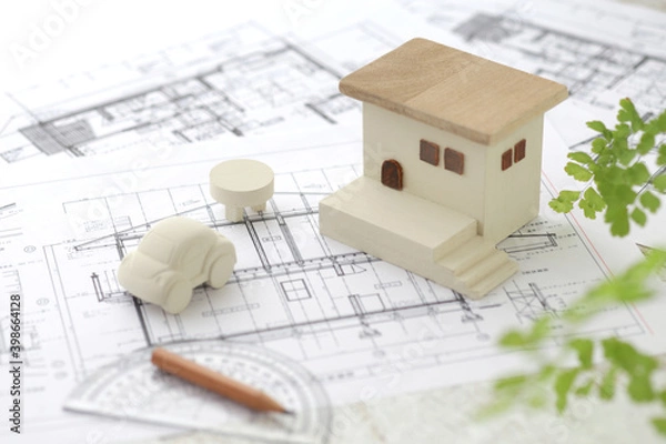 Fototapeta 木でできた家の模型とマイホームの設計図のイメージ