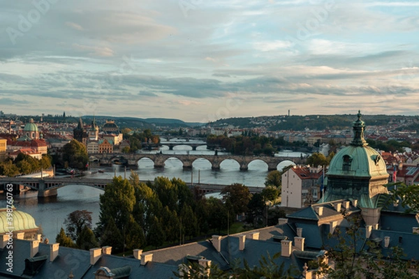 Fototapeta .view of prague at sunset on the vltava river and bridges on it and roofs of old buildings in the center of prague in czech republic