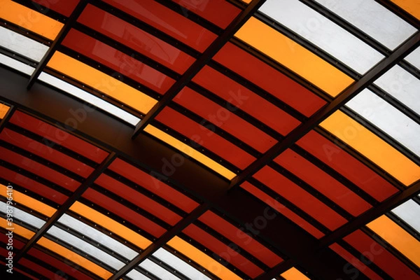 Obraz Architectural detail of the structure of a modern cover with metal frame and coloured glass curved panels in Amsterdam bus station