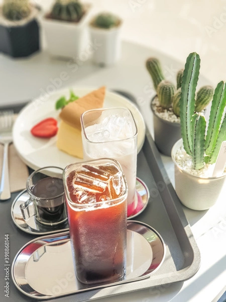 Fototapeta Table set for ice americano and ice chocolate milk served with home made cheese cake, Afternoon tea.
