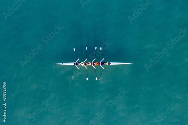 Obraz Sport Canoe with a team of four people rowing on tranquil water, Aerial view.