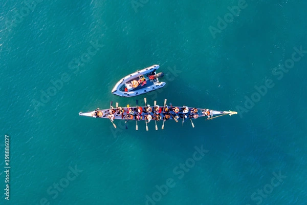 Obraz Dragon Boat team rowing to the pace of an onboard Drummer, Aerial view.