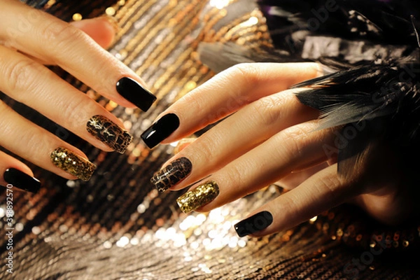 Obraz Holiday manicure on long square nails with Golden sequins, black shiny nail Polish and craquelure matte black coating.