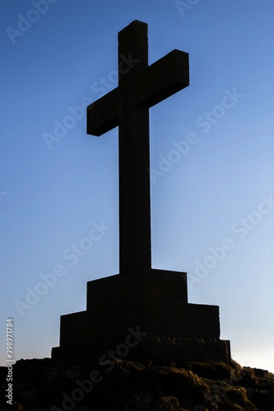 Fototapeta Saint Dwywen's Cross, Llanddwyn Island, Newborough, Anglesey. Large Anglican Christian Victorian memorial cross silhouette against the sky.