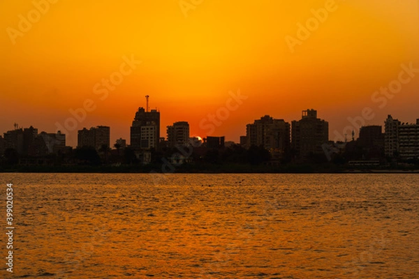 Fototapeta Sunset on the skyline of the city of Cairo, the sun goes down on the buildings of the city of Cairo in the background. Africa