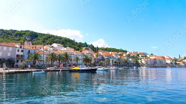 Fototapeta Panoramic view of Korcula coast with mountains, houses and boats on the harbor
