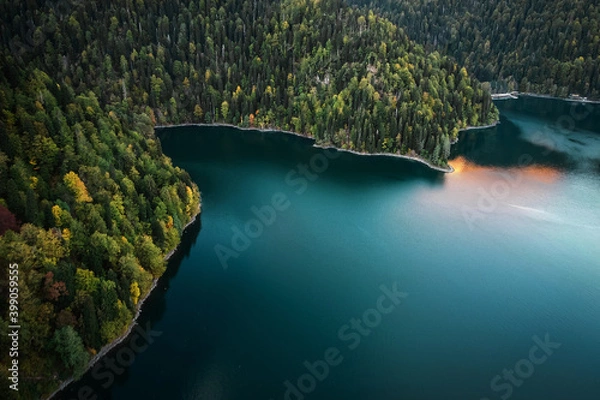 Fototapeta Beautiful mountain lake with trees on the shore and reflection of mountains and sunset