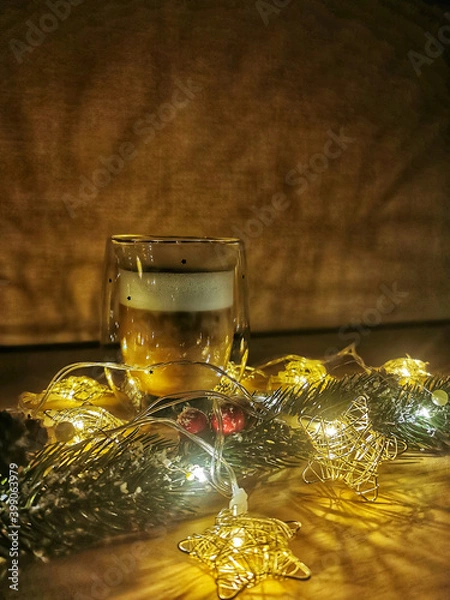 Fototapeta Christmas and new year's composition: a Cup of cappuccino, a branch of spruce and garlands