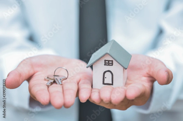 Fototapeta businessman with house model and keys, real estate agent with house model and keys
