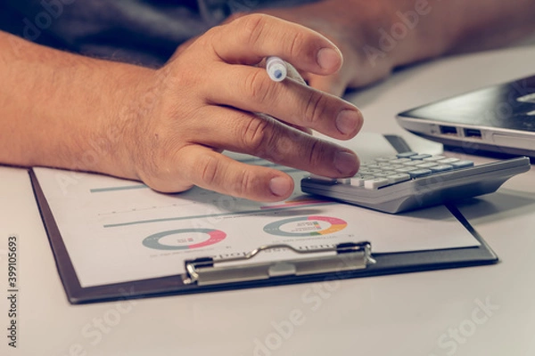 Fototapeta Close up of businessman hands calculating earnigs business performance