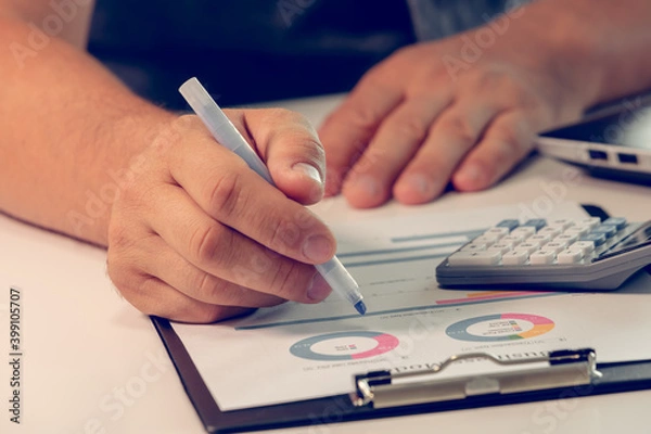 Fototapeta Businessman working with financial data hand using calculator and making calculations. Business financial and accounting concept.