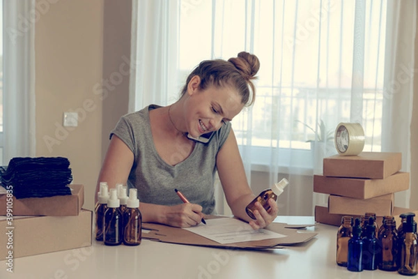 Fototapeta Woman sitting at table with cardboard boxes