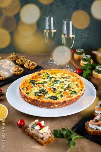 Fototapeta Shrimp, salmon , broccoli and spinach pie for Christmas celebration with bokeh lights. Delicious home made tart for family dinner or New year party