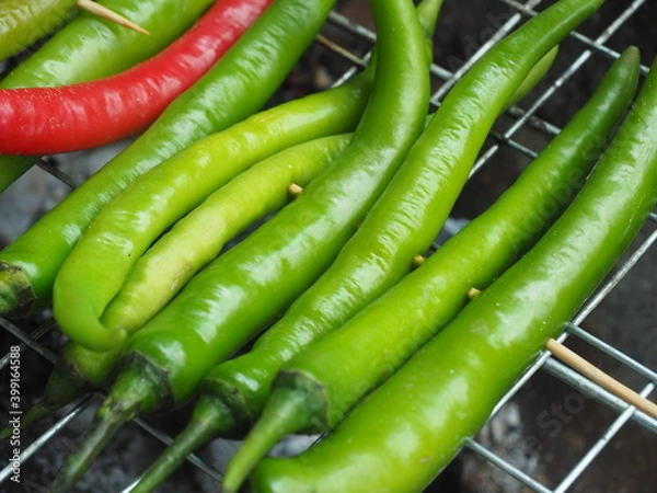 Obraz Young green chilli grill on Grill grate before cooking Northern Thai Green Chilli Dip, Called "Nam Prik Num", Selective focus.