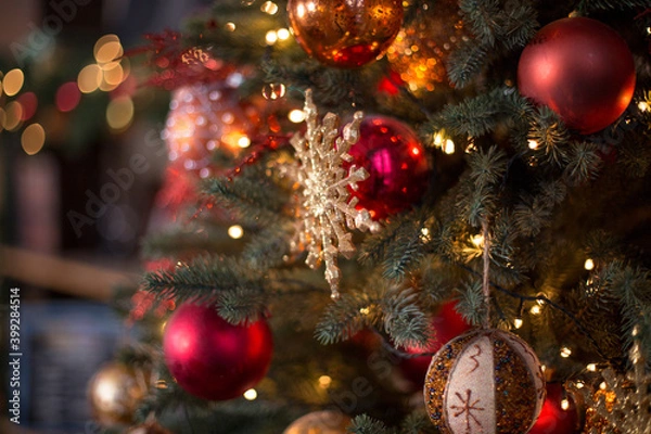 Fototapeta The New Year's tree with gifts and Christmas toys. Christmas tree and bokeh lights. Сhristmas ball and snowflake hanging on the tree. Decorated christmas tree.