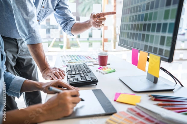 Fototapeta Young colleagues designers working together on a creative project and color samples for selection, Color swatch samples, Brainstorming Planning Partnership, creative graphic design working desktop