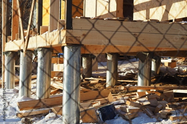 Fototapeta Building a house from a beam on stilts. High quality