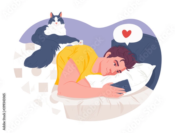 Fototapeta Guy lies in bed with phone in hands. Communication on social networks, messenger with friends or loved one. Funny cat cheekily lay down on top of him. Leisure, social media, modern technology concept 
