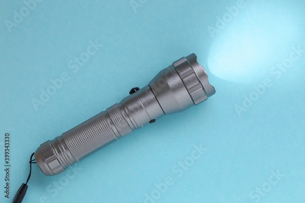 Fototapeta led flashlight on a blue surface