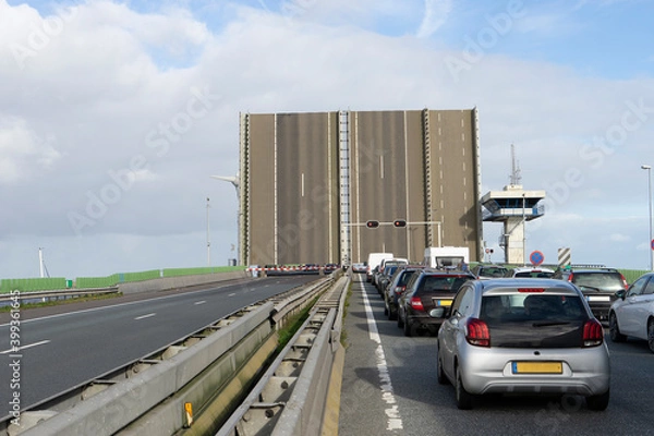 Fototapeta Open bridge with cued cars waiting at Ketelbridge Lelystand The Netherlands