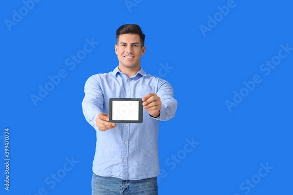 Fototapeta Young man with e-reader on color background