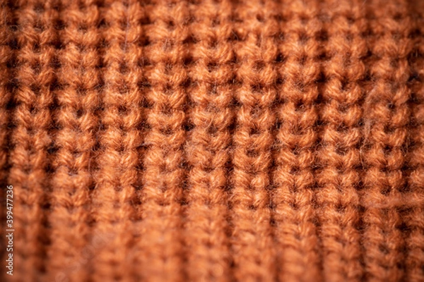 Fototapeta Orange wool scarf background texture. Macro photo with selective focus.