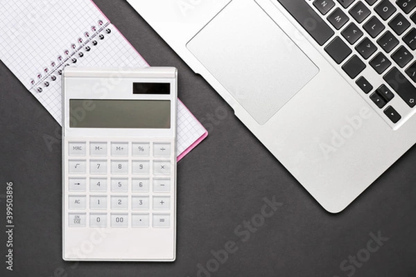 Fototapeta Modern calculator, notebook and laptop on dark background