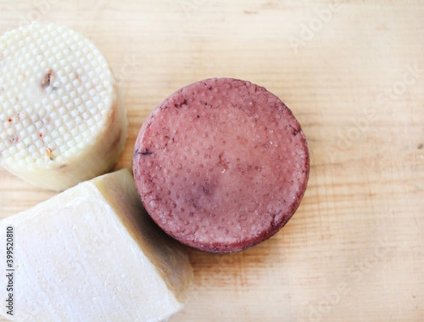 Fototapeta Farmer's cheese crust of cheese with grains inside. the texture as it Matures is handmade. pieces of cheese on a cutting Board in different colors of Derby, caciotta, cheddar